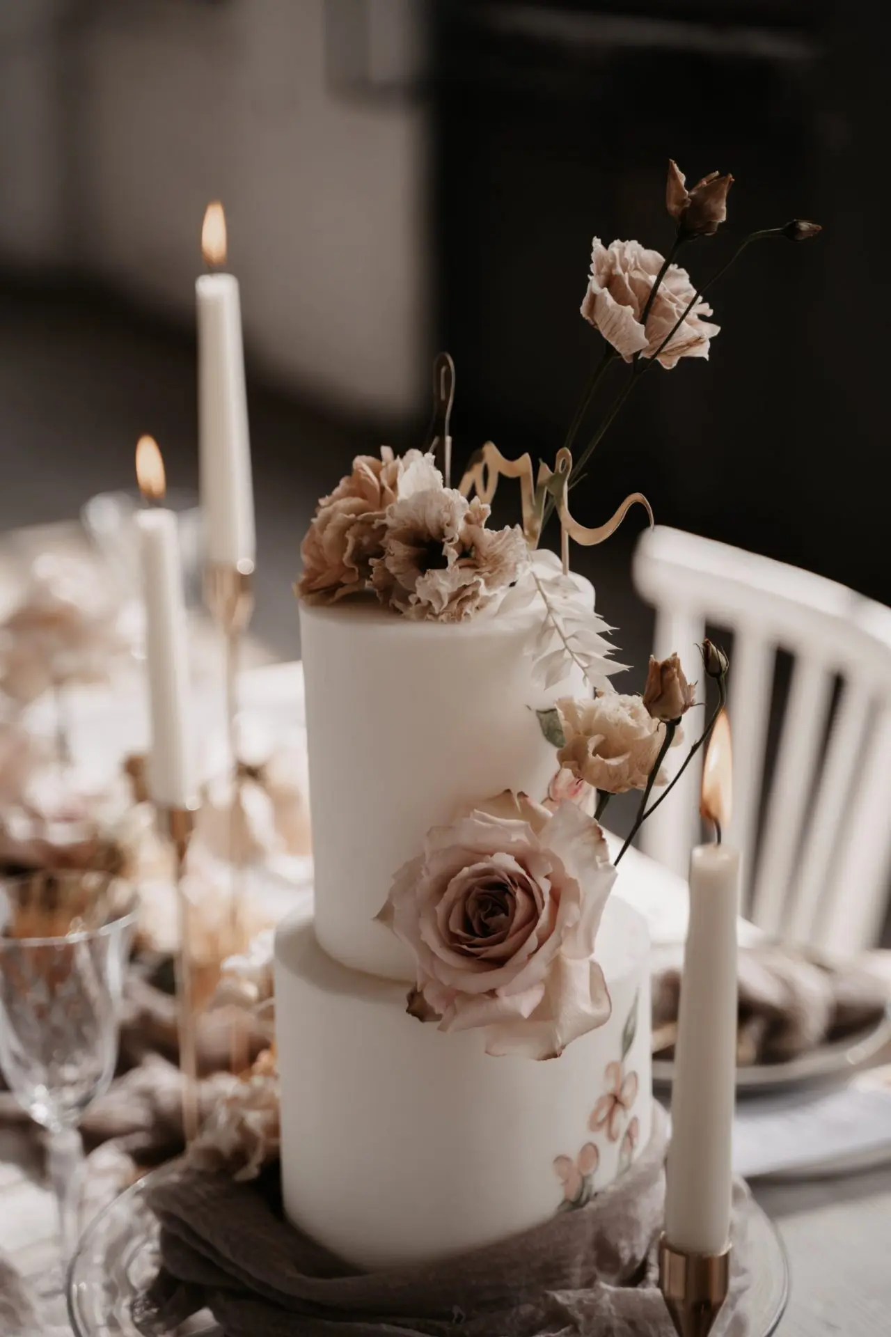 Hochzeitstorte zwei Stöcke, auf einem dekorierten Tisch. Kerzen, Blumen.